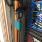 Storage clip holding a Dyson V7 or V8 stick vacuum wand upright on a broom handle, view 5