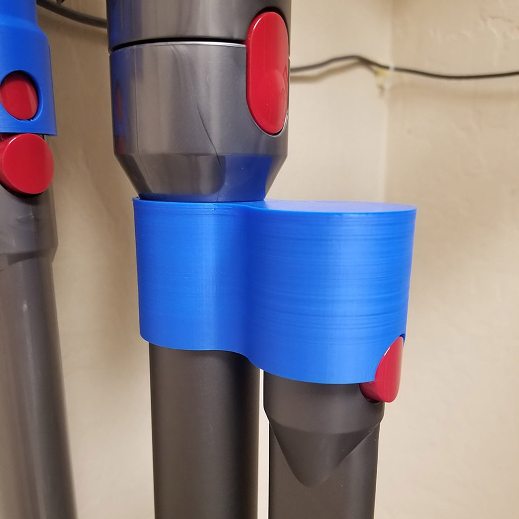 Storage clip holding a Dyson V7 or V8 stick vacuum wand upright on a broom handle