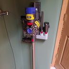 Wall mount attachment holder docking a Dyson V8 vacuum with four tool slots, view 3