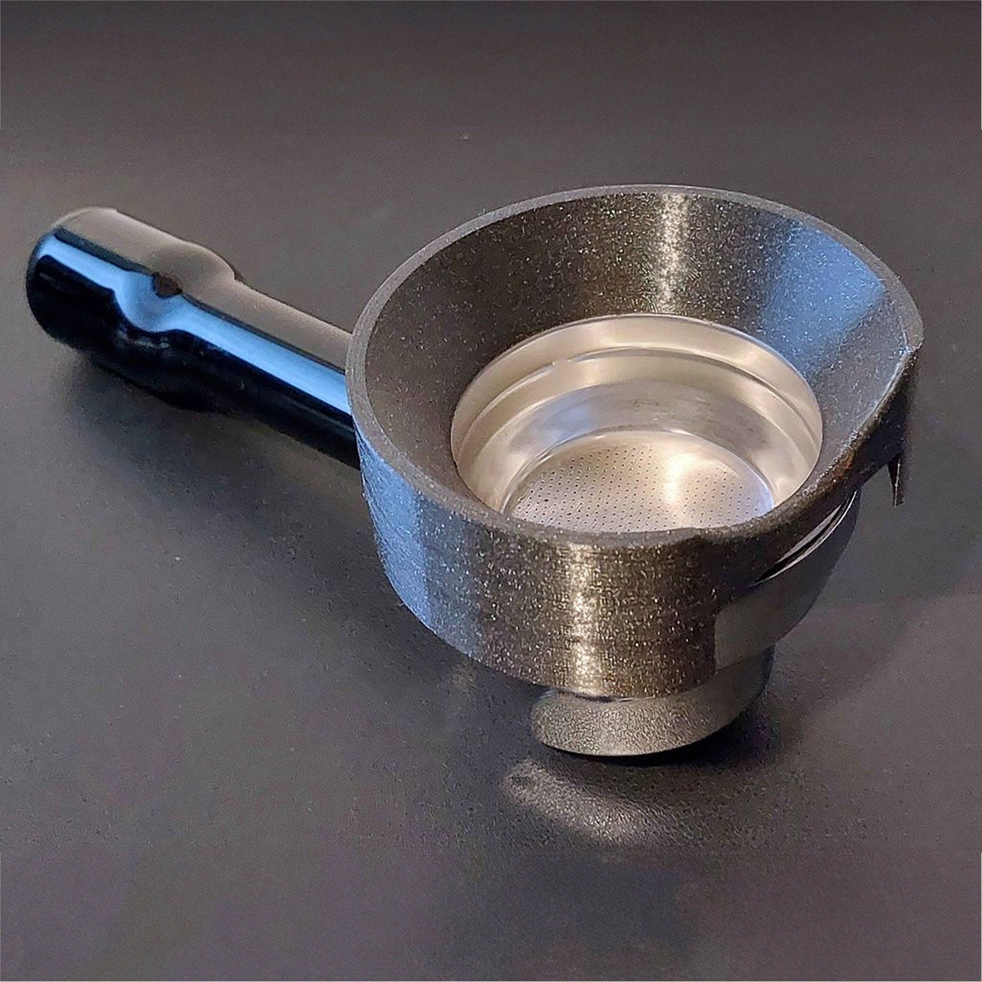 a stainless steel measuring cup with a blue handle