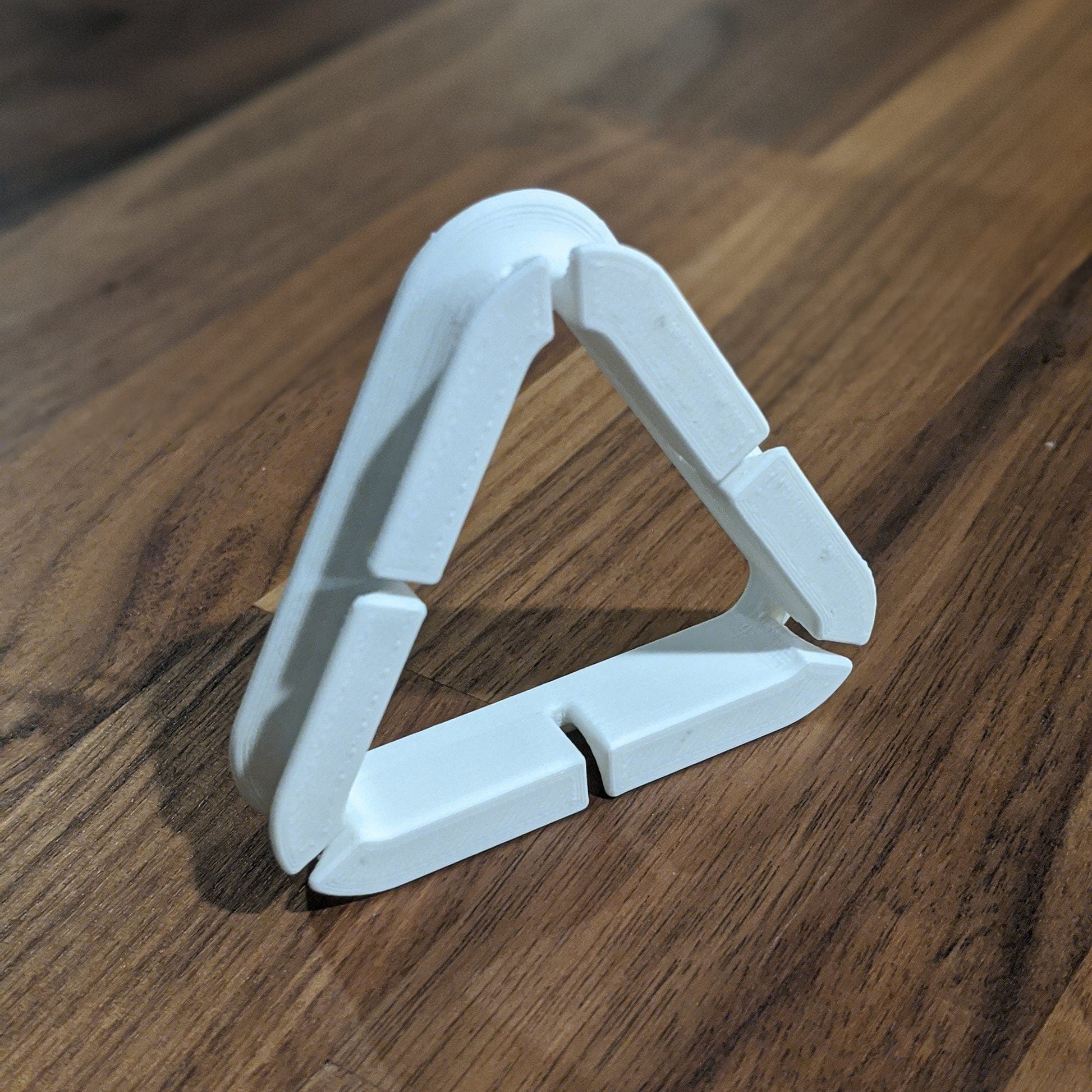 a triangle shaped object sitting on top of a wooden table