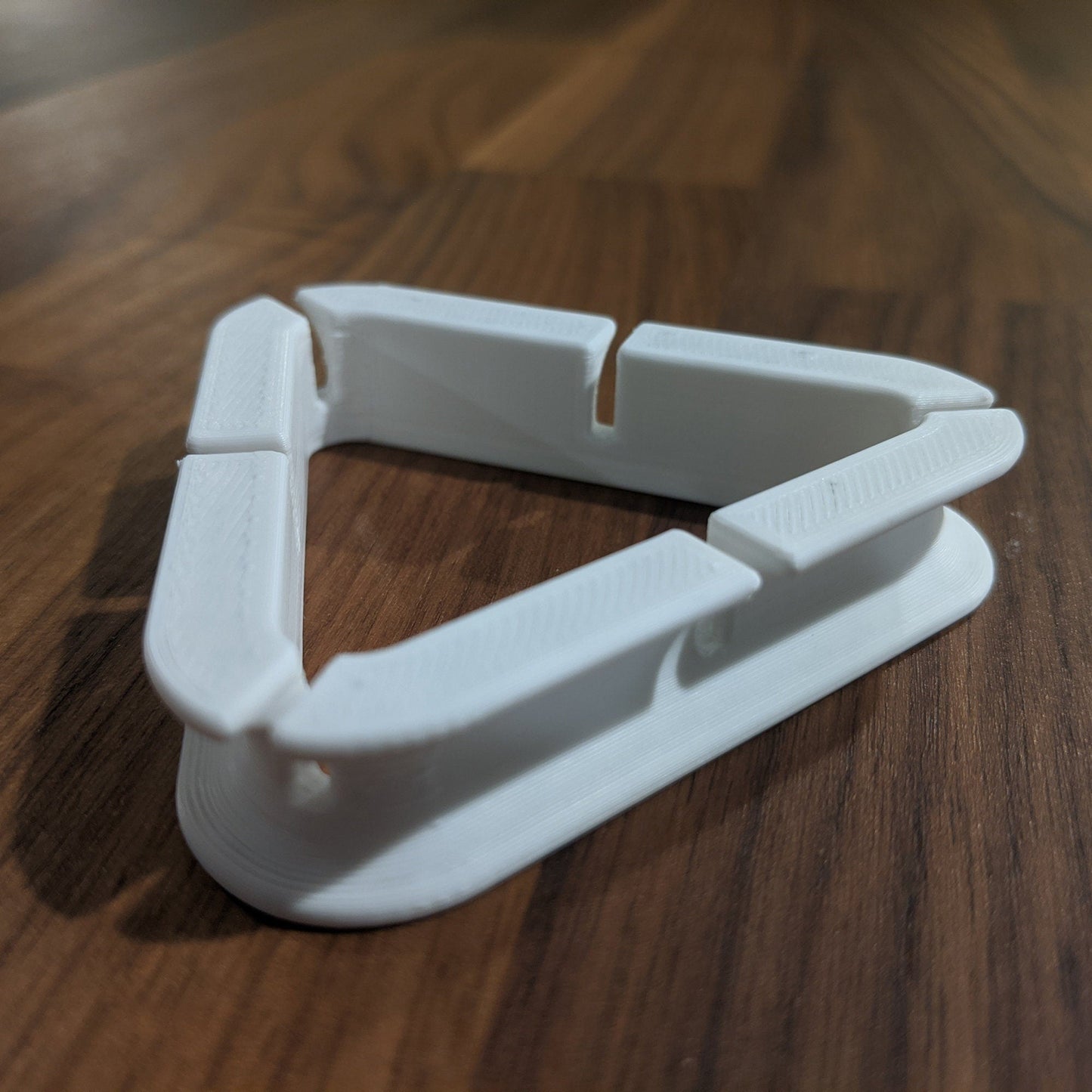 a white plastic object sitting on top of a wooden table