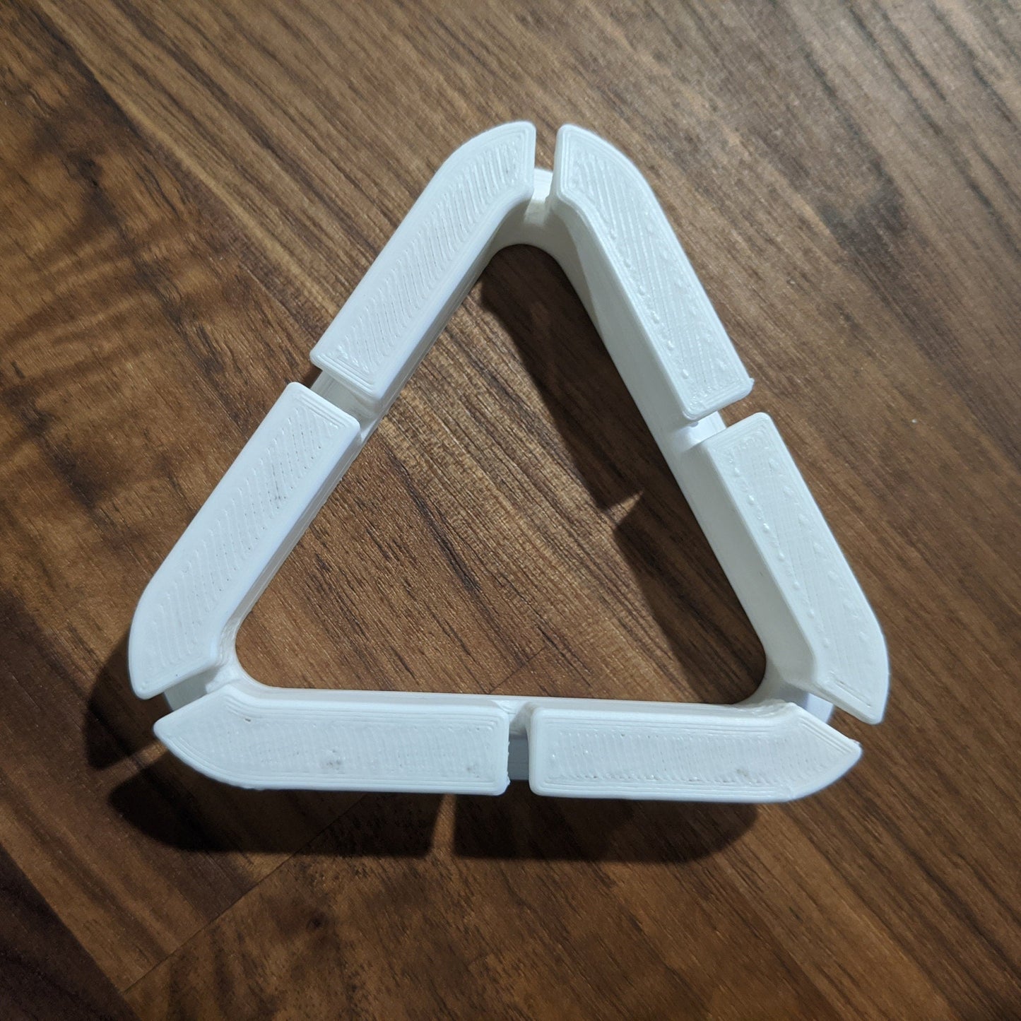 a triangle shaped object sitting on top of a wooden table