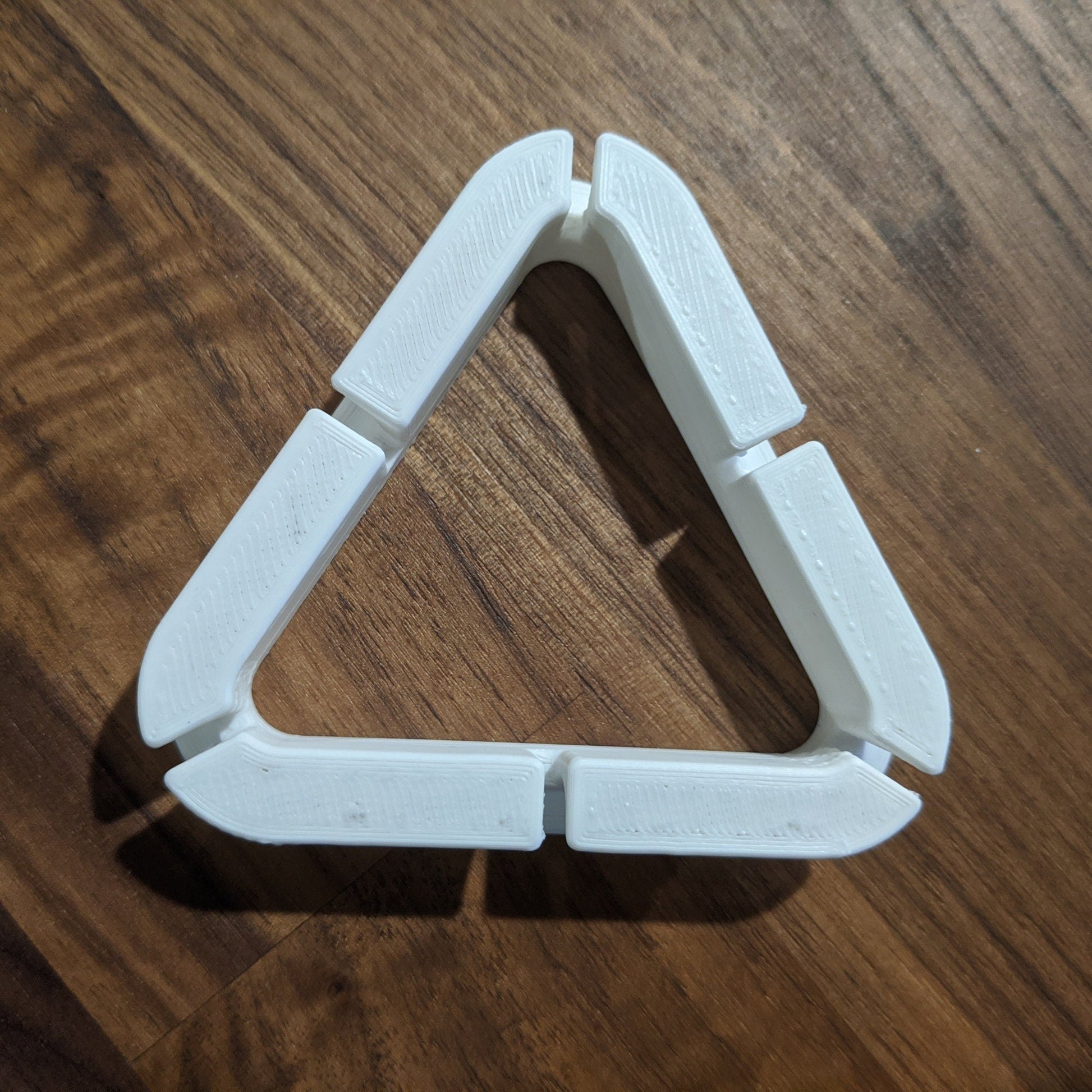 a triangle shaped object sitting on top of a wooden table