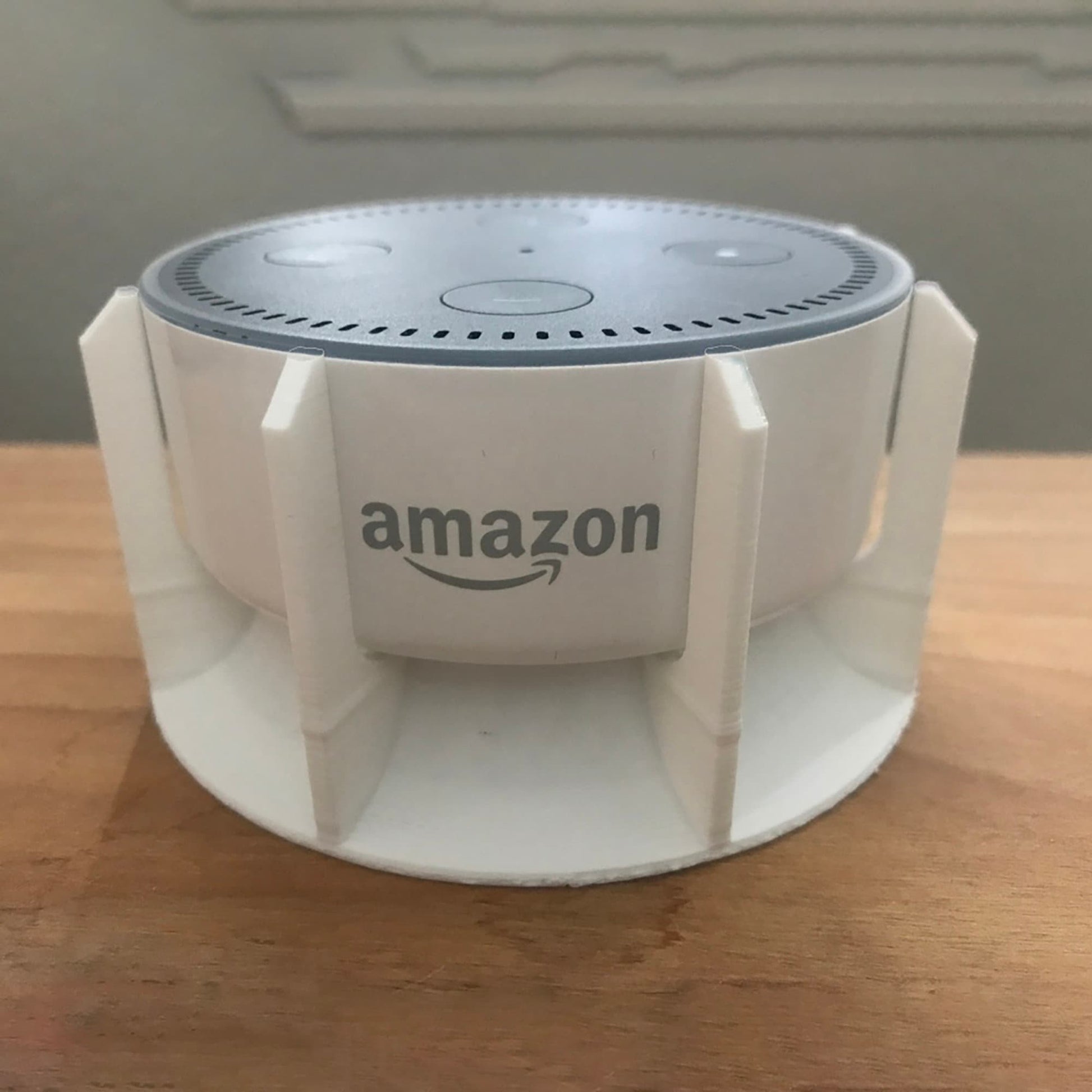 a white amazon speaker sitting on top of a wooden table