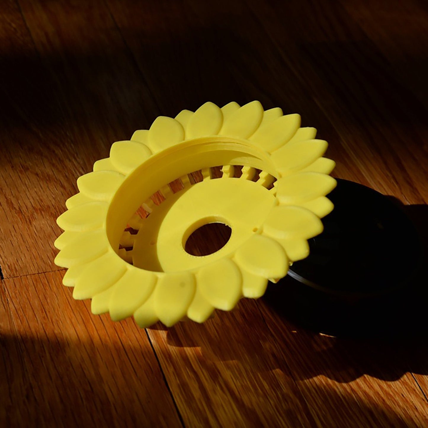 a yellow plastic object sitting on top of a wooden floor