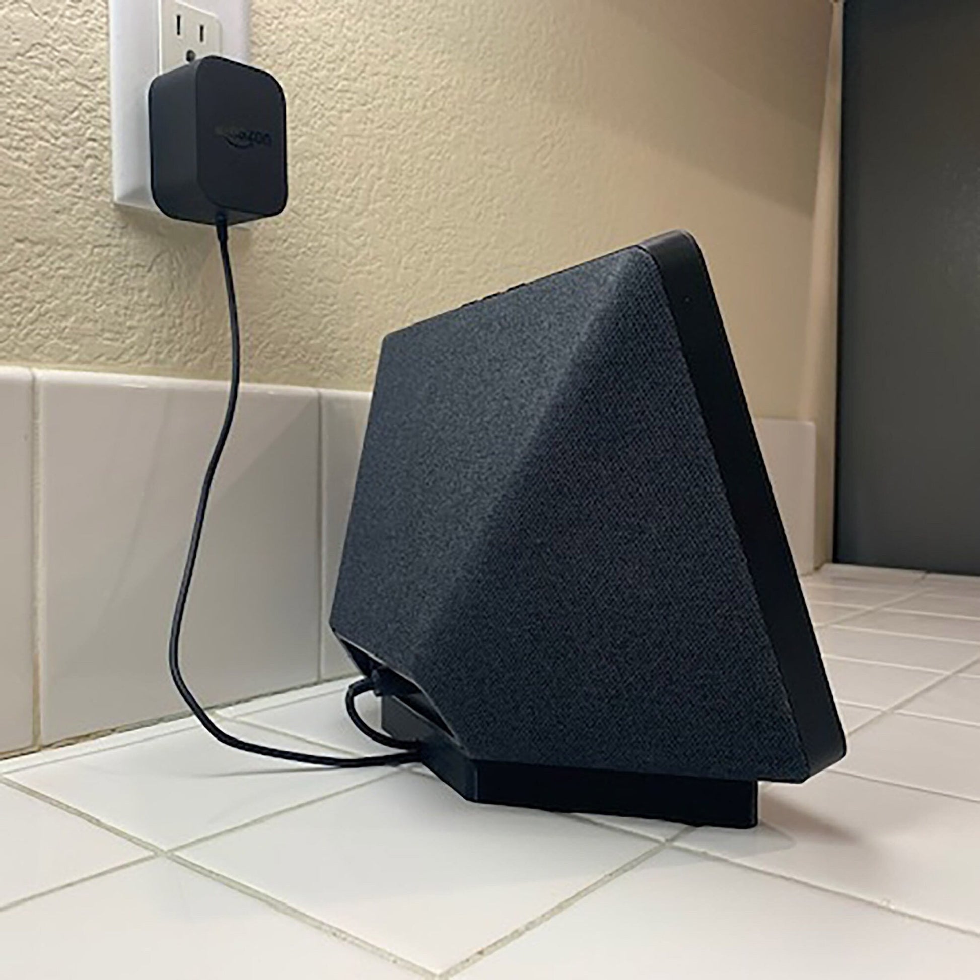 a black speaker plugged into a wall outlet