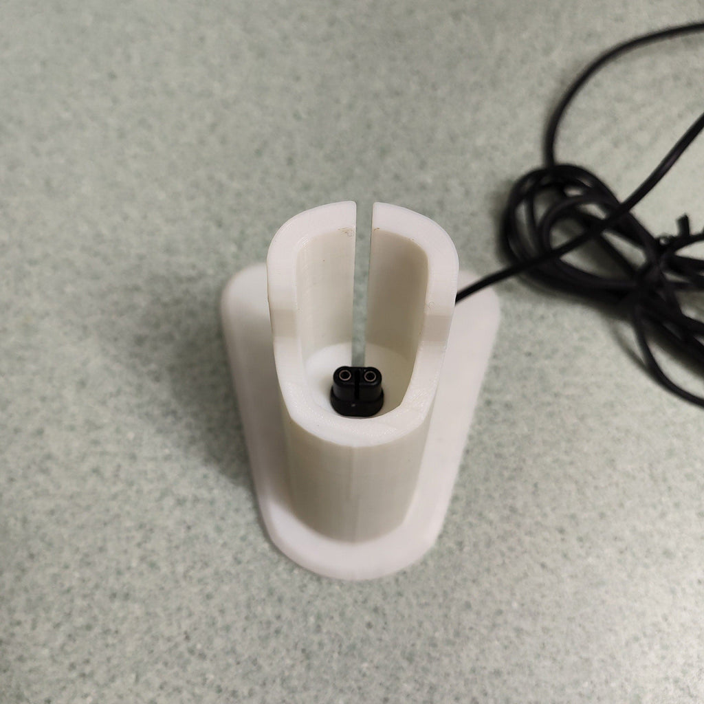 Charging stand holding a Philips OneBlade QP2520 razor upright, view 2