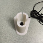 Charging stand holding a Philips OneBlade QP2520 razor upright, view 2