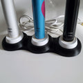Multi-slot stand holding several Oral-B charging docks side by side