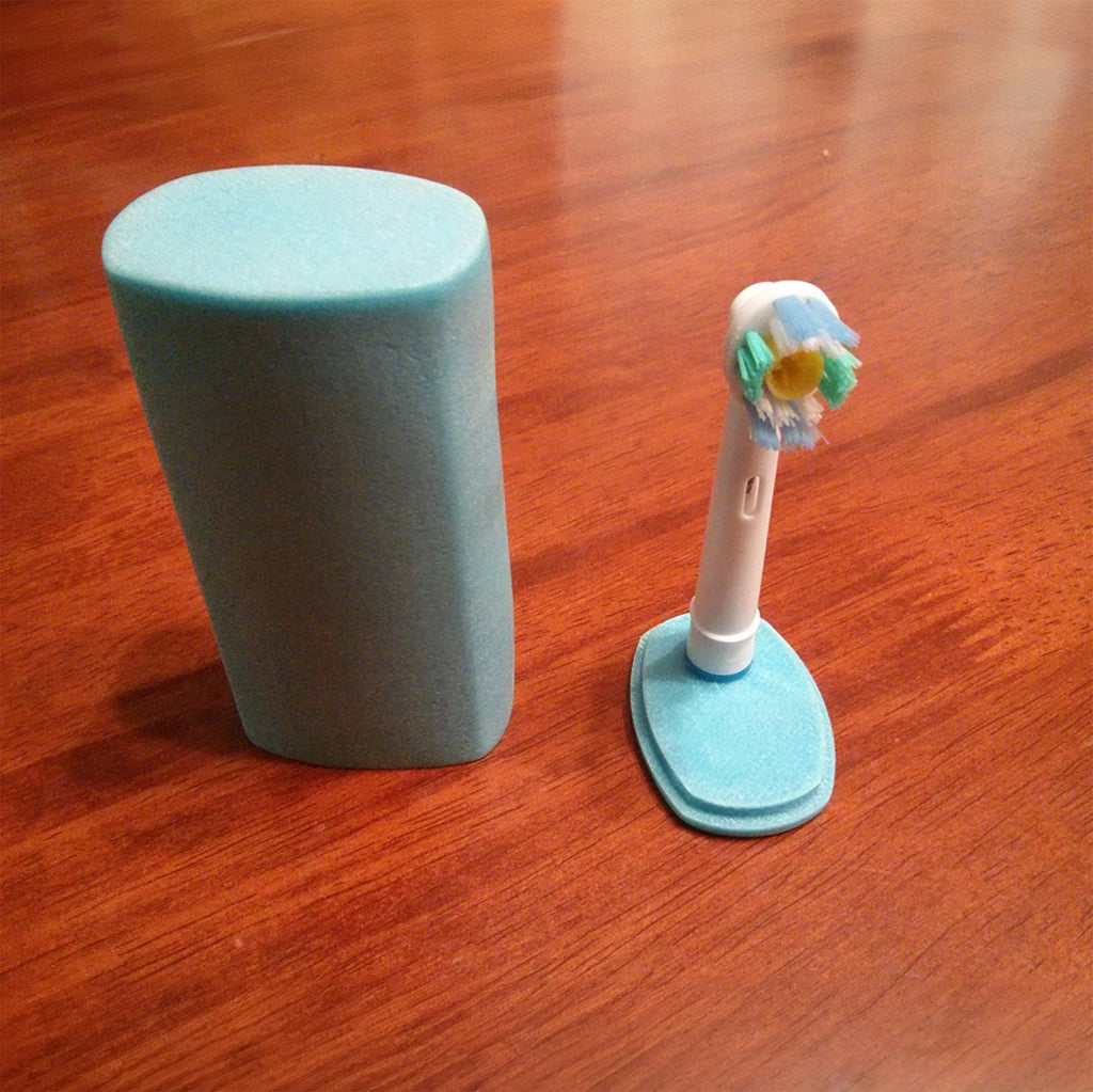 Tall travel cap covering an Oral-B brush head on its stand