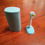 Tall travel cap covering an Oral-B brush head on its stand