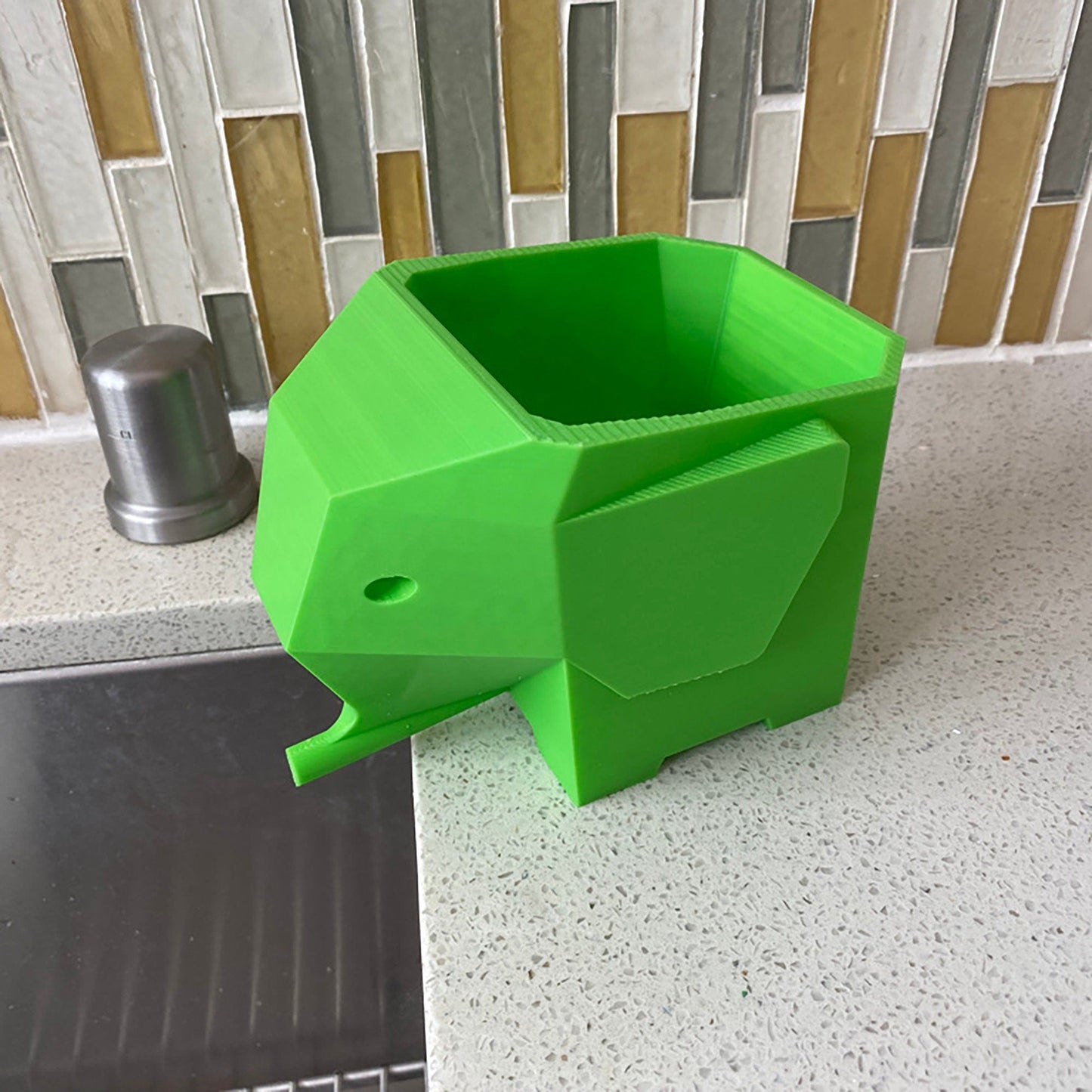 a green elephant shaped container sitting on top of a counter