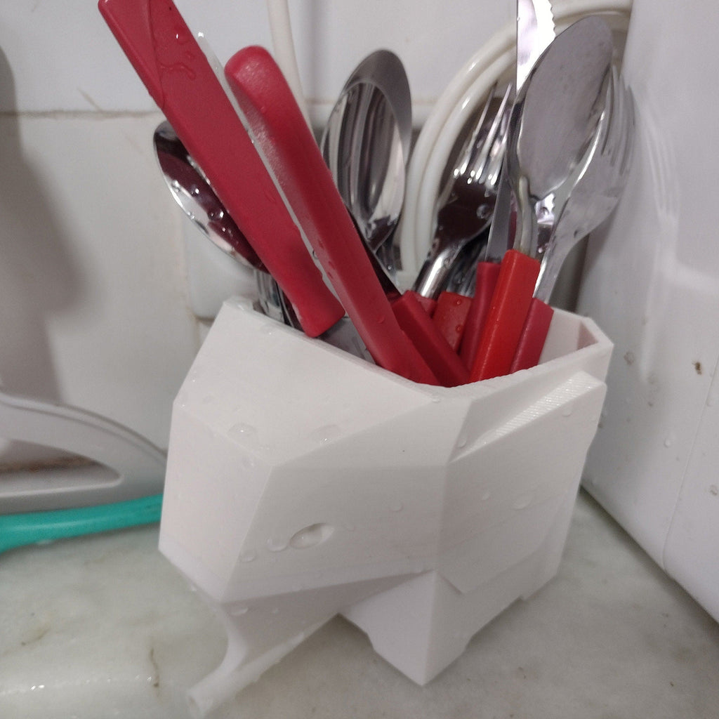 Geometric elephant utensil holder draining cutlery into the sink