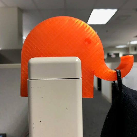 an orange elephant head sticking out of the back of a refrigerator