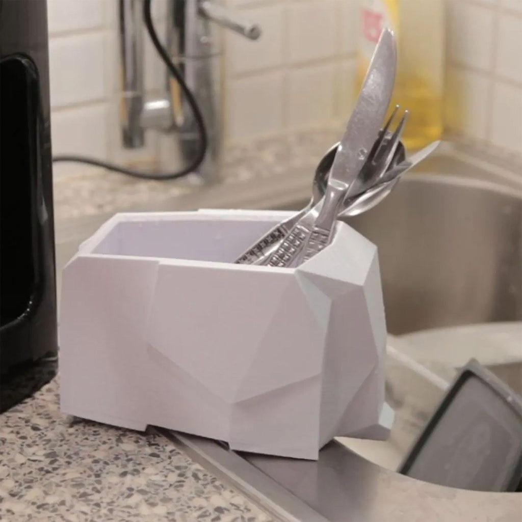 Faceted elephant sponge holder at the edge of a kitchen sink