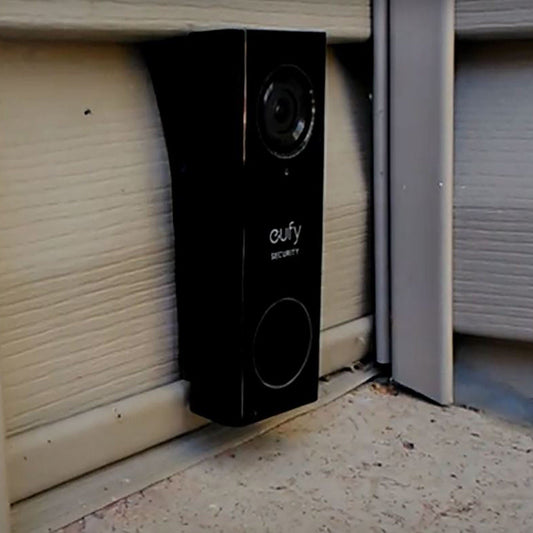 a black speaker sitting in front of a garage door