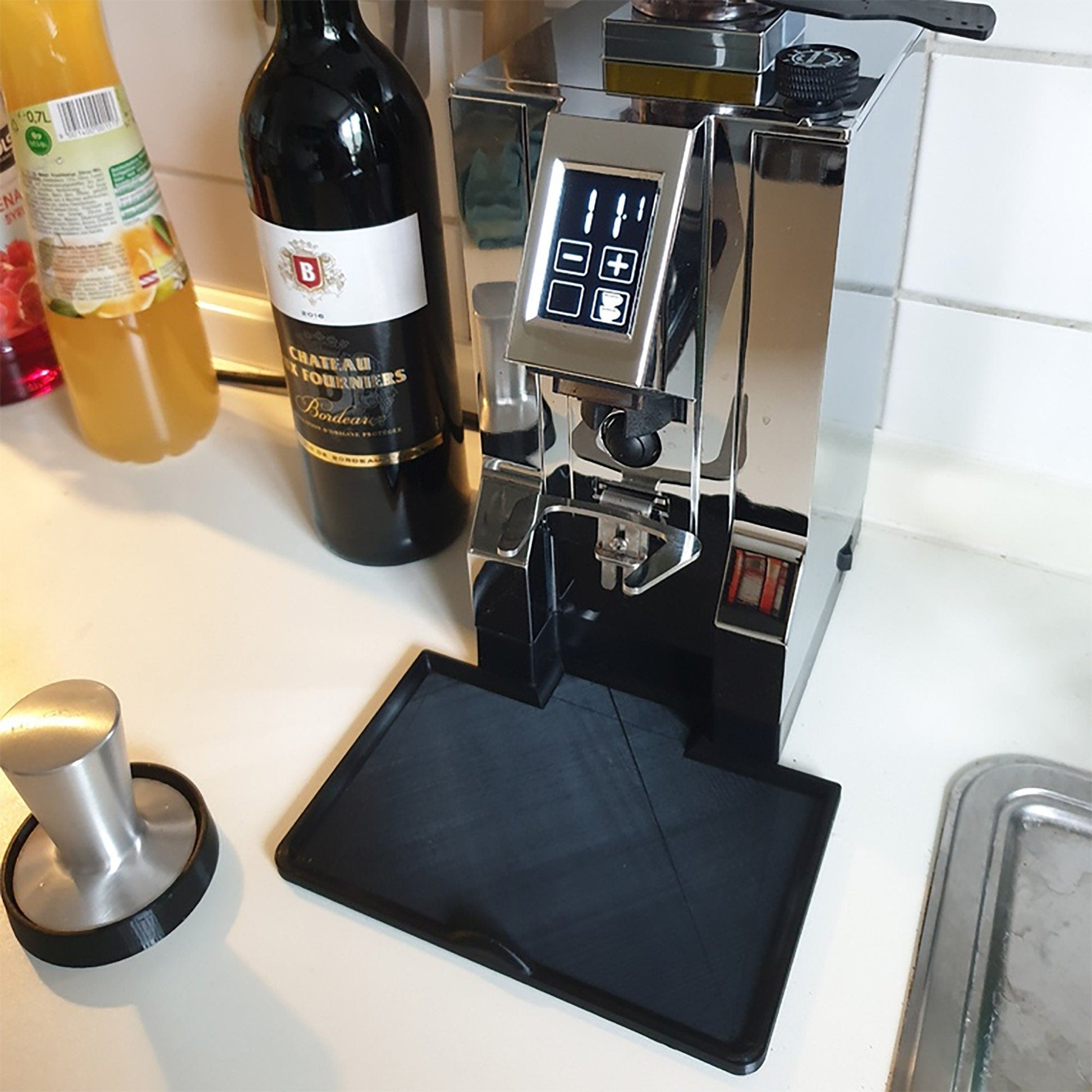 a coffee machine sitting on top of a counter next to a bottle of wine