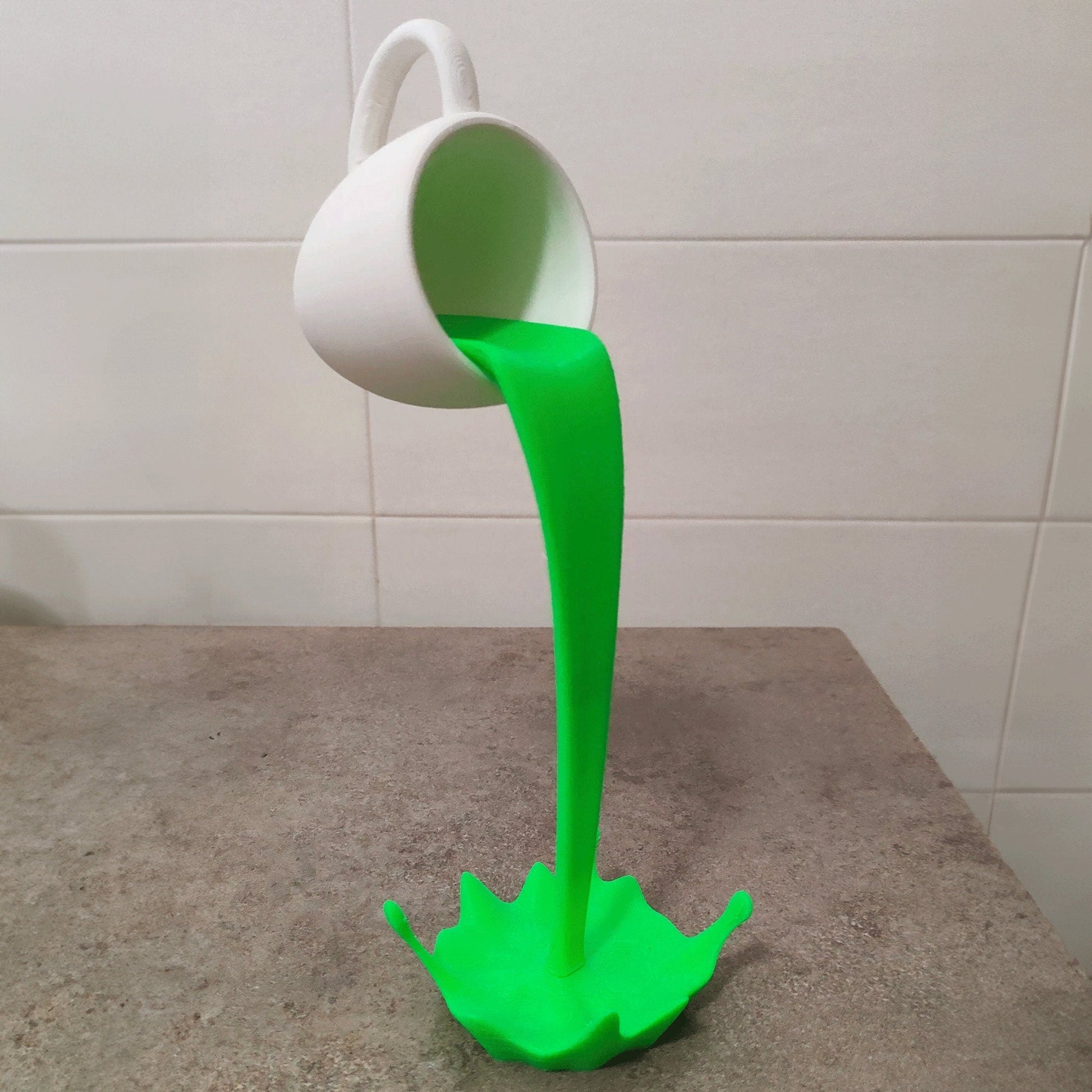 a green liquid pouring out of a white cup