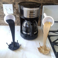 a kitchen counter with a coffee maker and two spoons