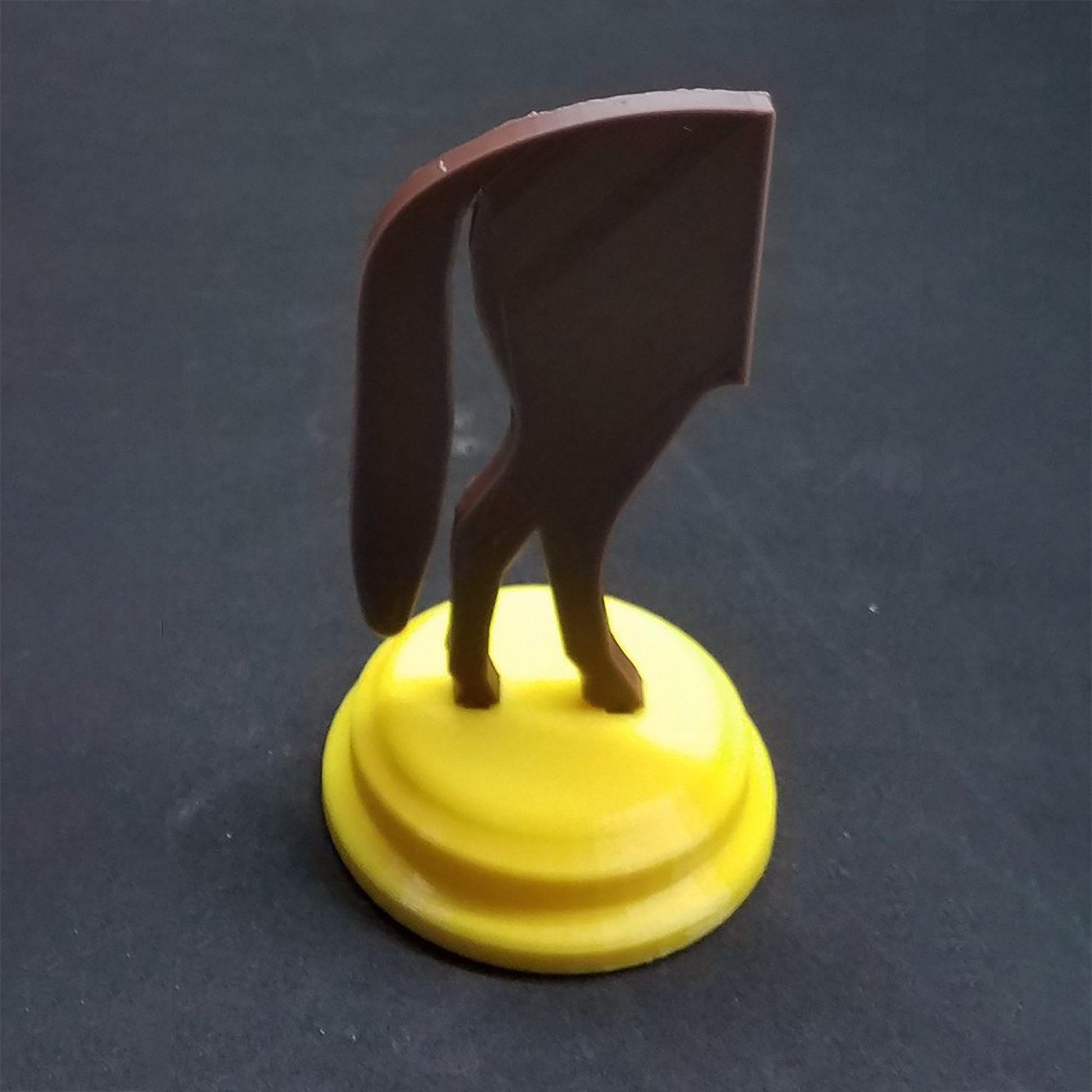 a small figurine of a cat on a yellow base