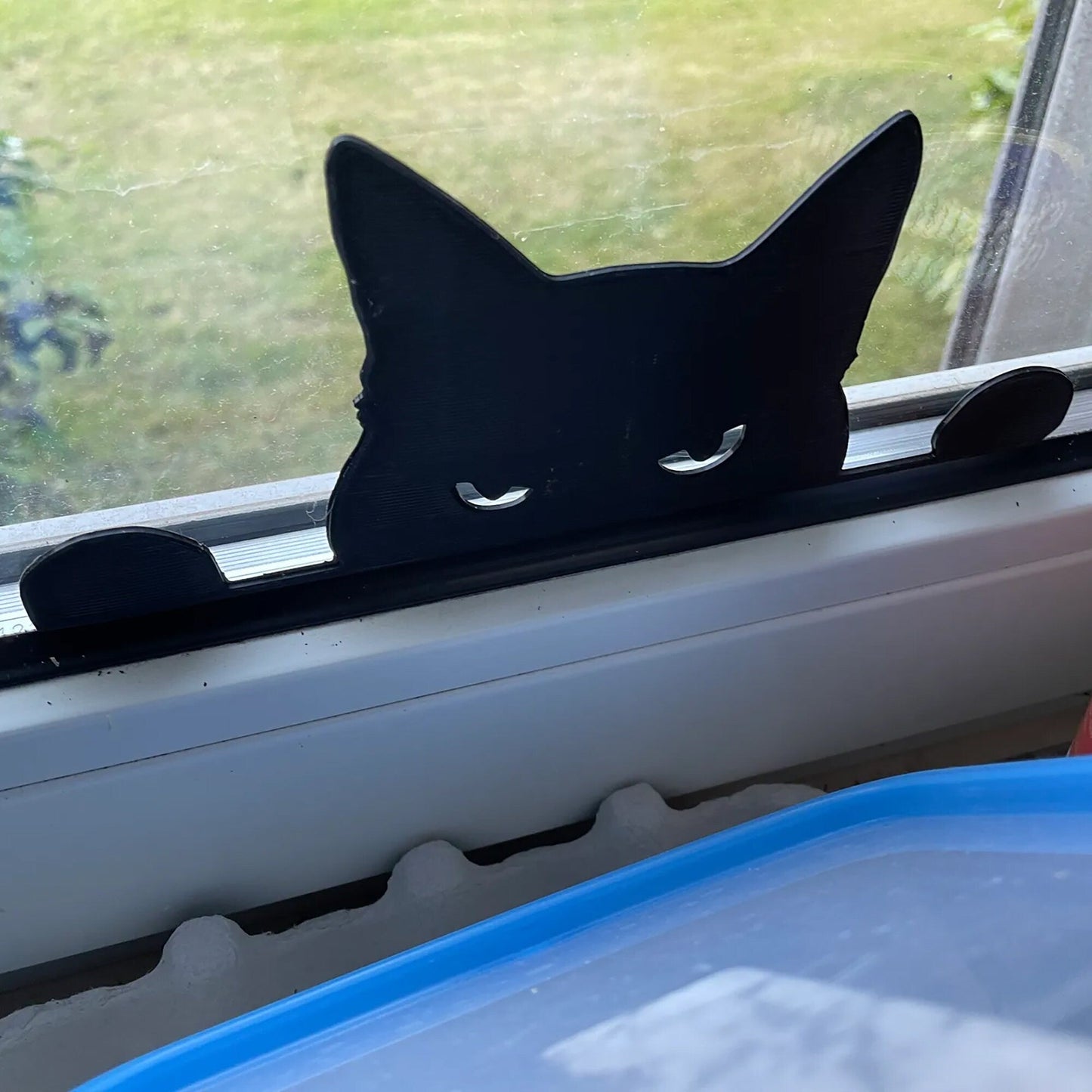 a black cat sitting on top of a window sill