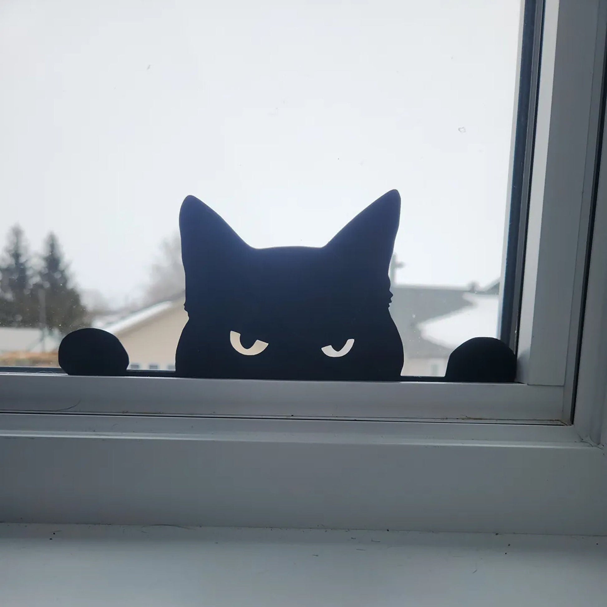 a black cat sitting on top of a window sill