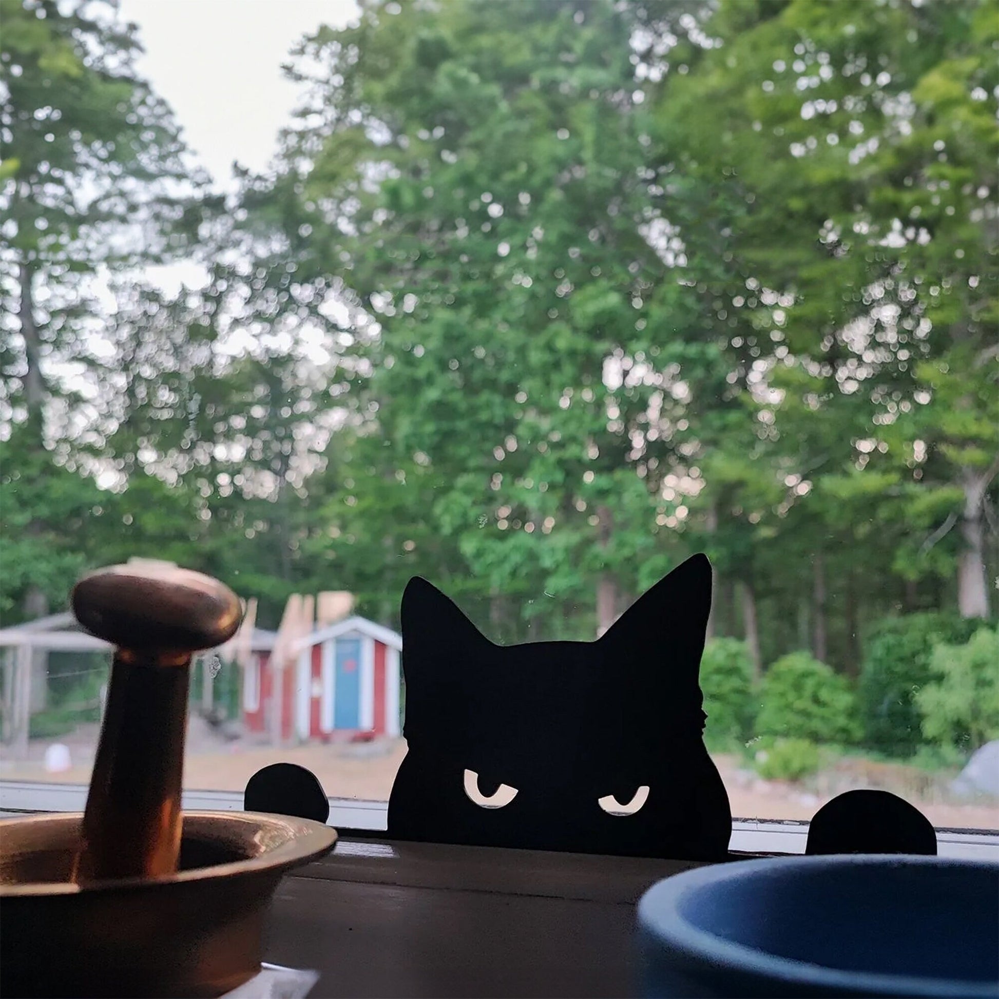 a black cat sitting on top of a window sill