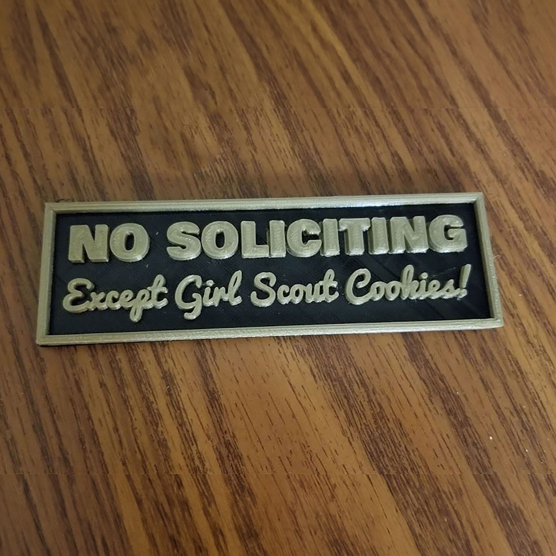 a wooden table with a sign on it stating no solicing except girl scout cookies