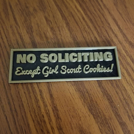 a wooden table with a sign on it stating no solicing except girl scout cookies