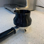 Dosing funnel on a 54mm portafilter basket for Breville Barista espresso machines
