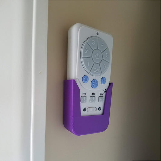 a purple and white remote control attached to a wall