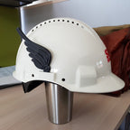 Pair of feathered clip-on wings on the sides of a construction hard hat