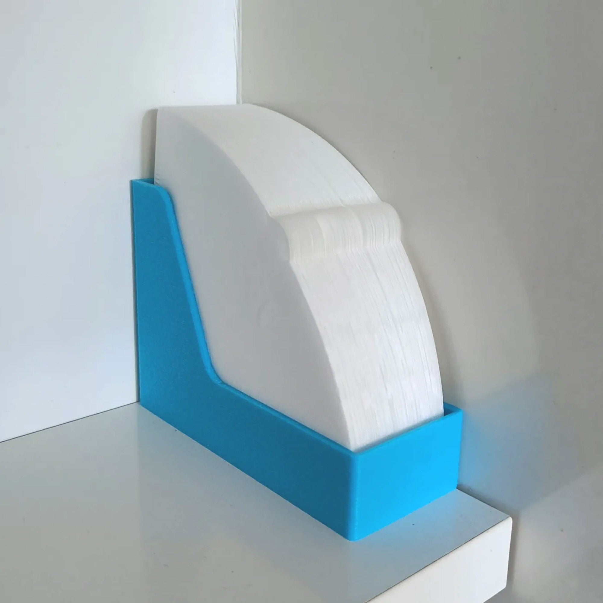 a blue and white tissue dispenser on a white surface