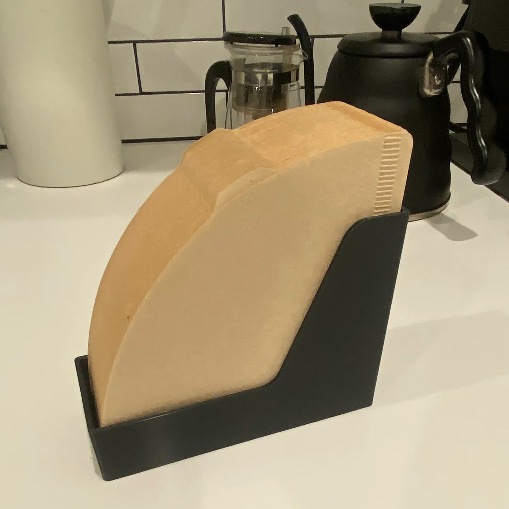 a knife holder on a counter next to a coffee pot