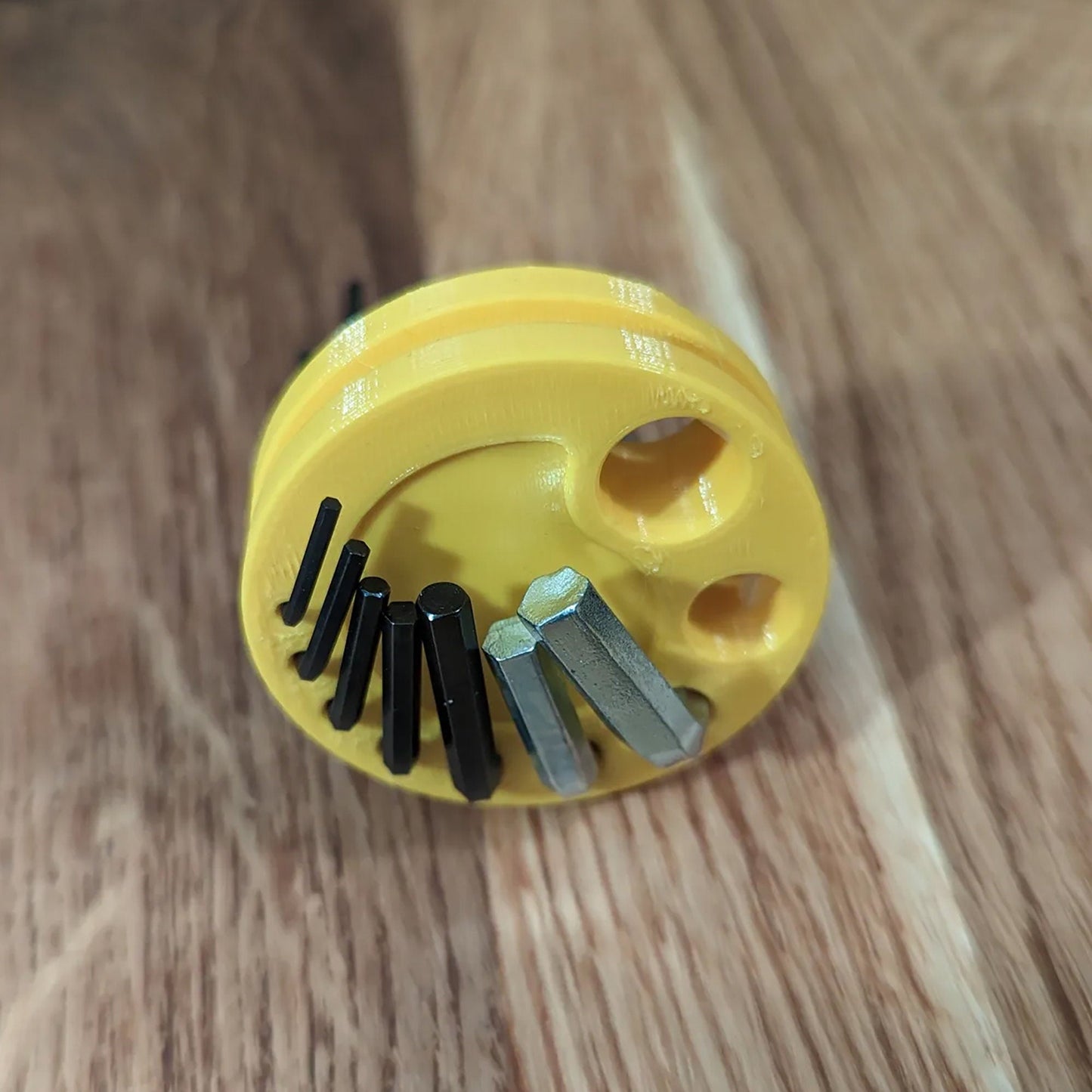 a yellow brush with a bunch of screws in it