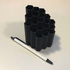 Honeycomb pen and pencil holder with hexagon slots on a desk, view 2