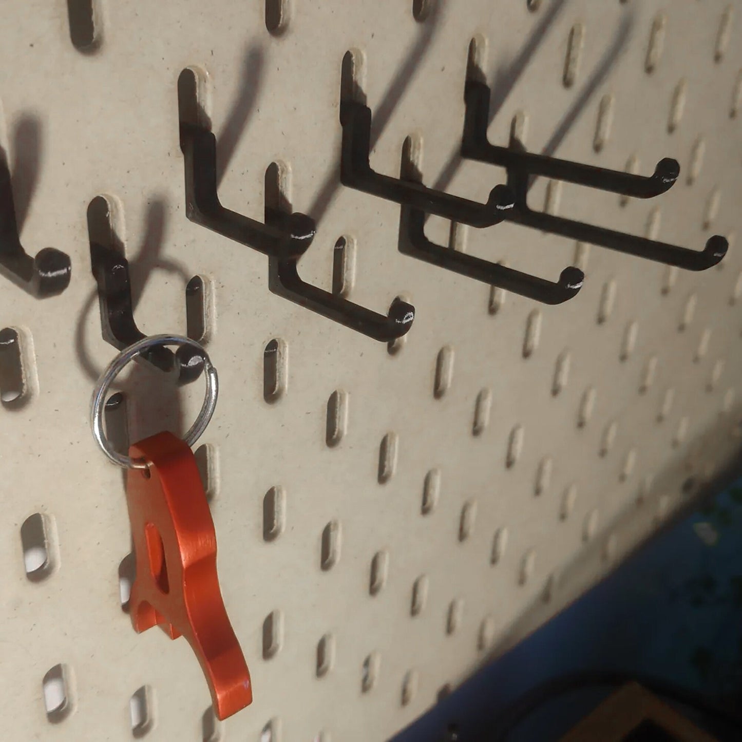 a metal pegboard with a bunch of hooks on it