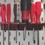 Screwdriver holder for IKEA SKADIS pegboard with angled slots holding drivers handle up, view 4