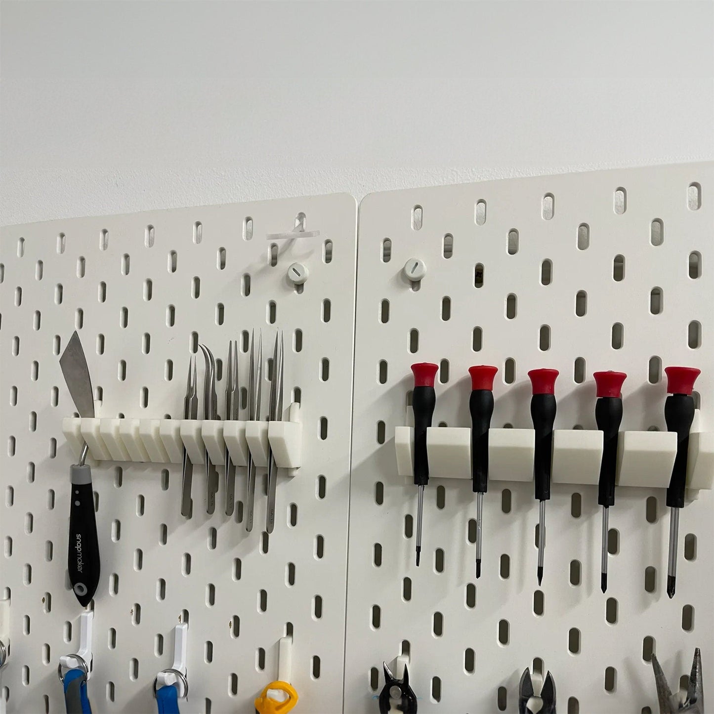 a peg board with a bunch of tools hanging on it