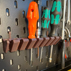 Screwdriver holder for IKEA SKADIS pegboard with angled slots holding drivers handle up