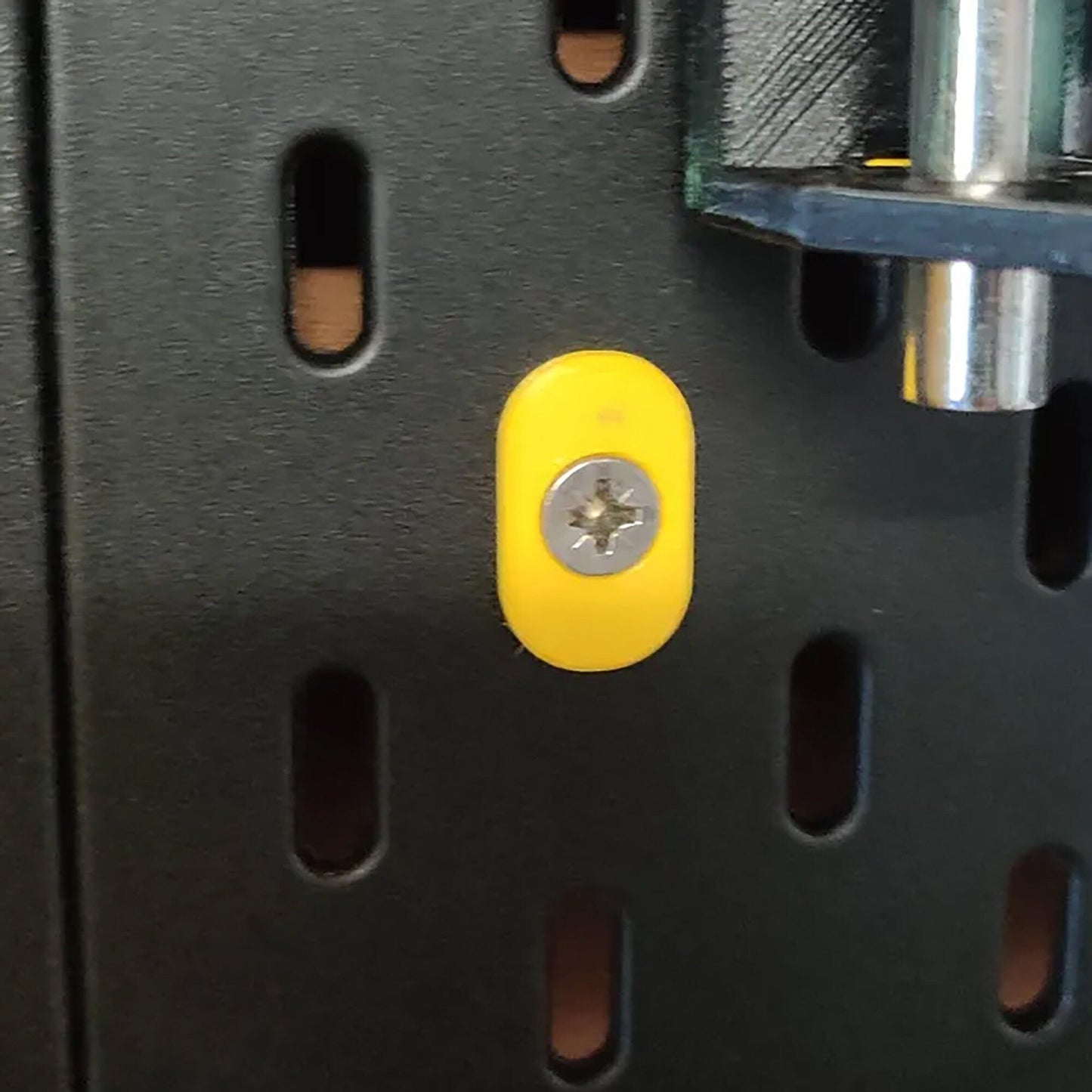 a close up of a metal object with a yellow button