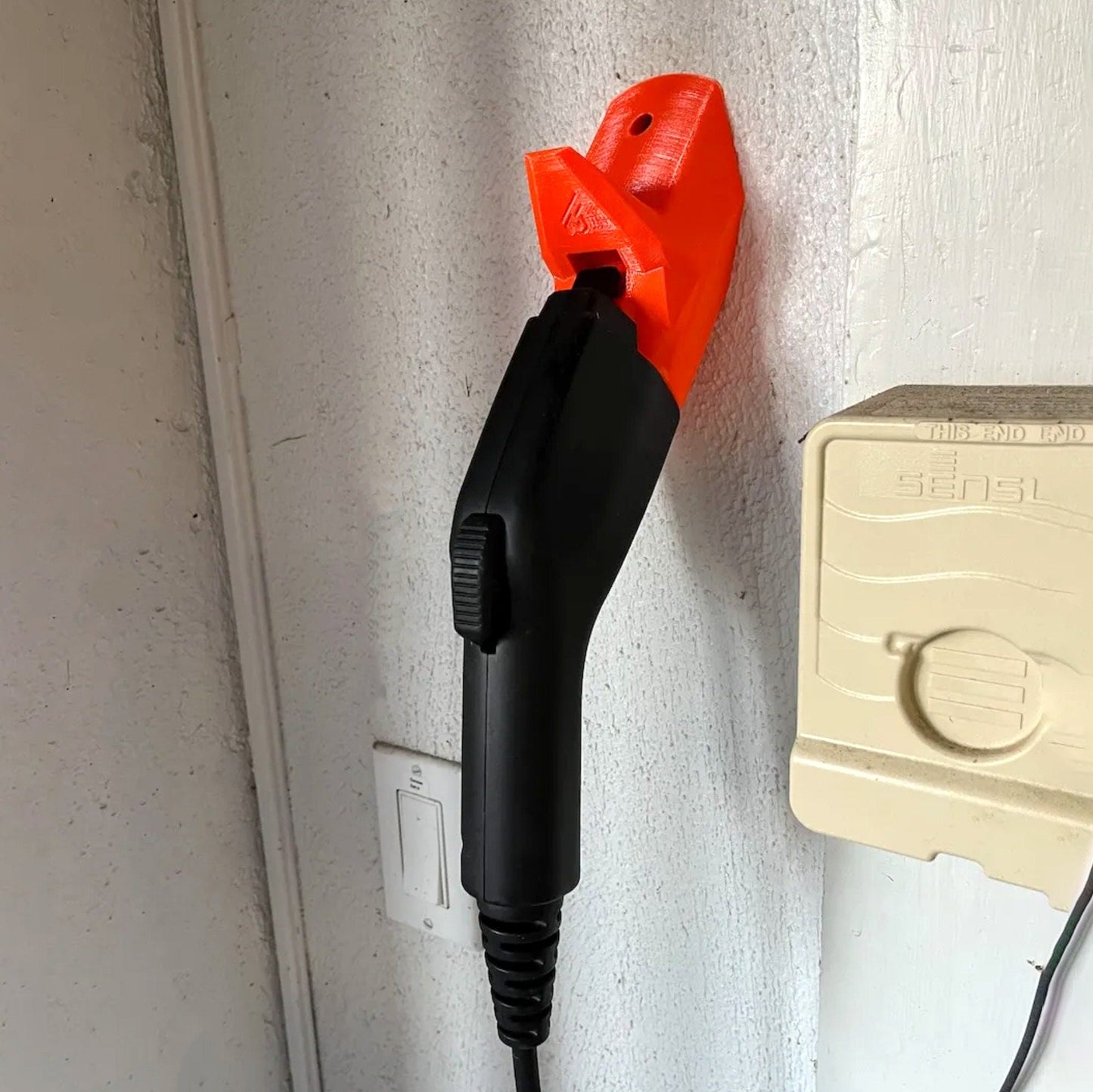 an orange and black blow dryer plugged into a wall