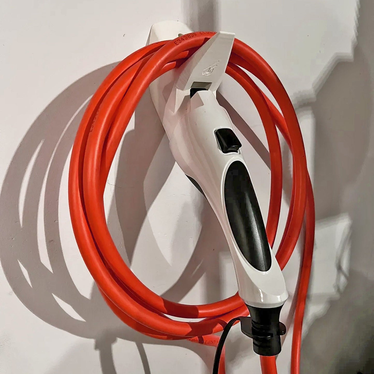 a red and white cord connected to a white wall