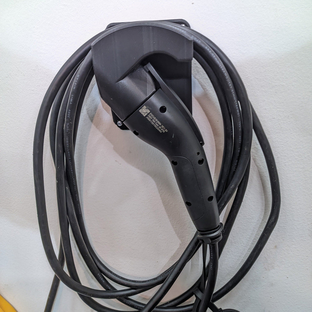 J1772 plug holder with flat backplate holding an EV charging connector nose-down