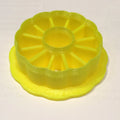 a yellow plastic cake plate with a ring on top of it