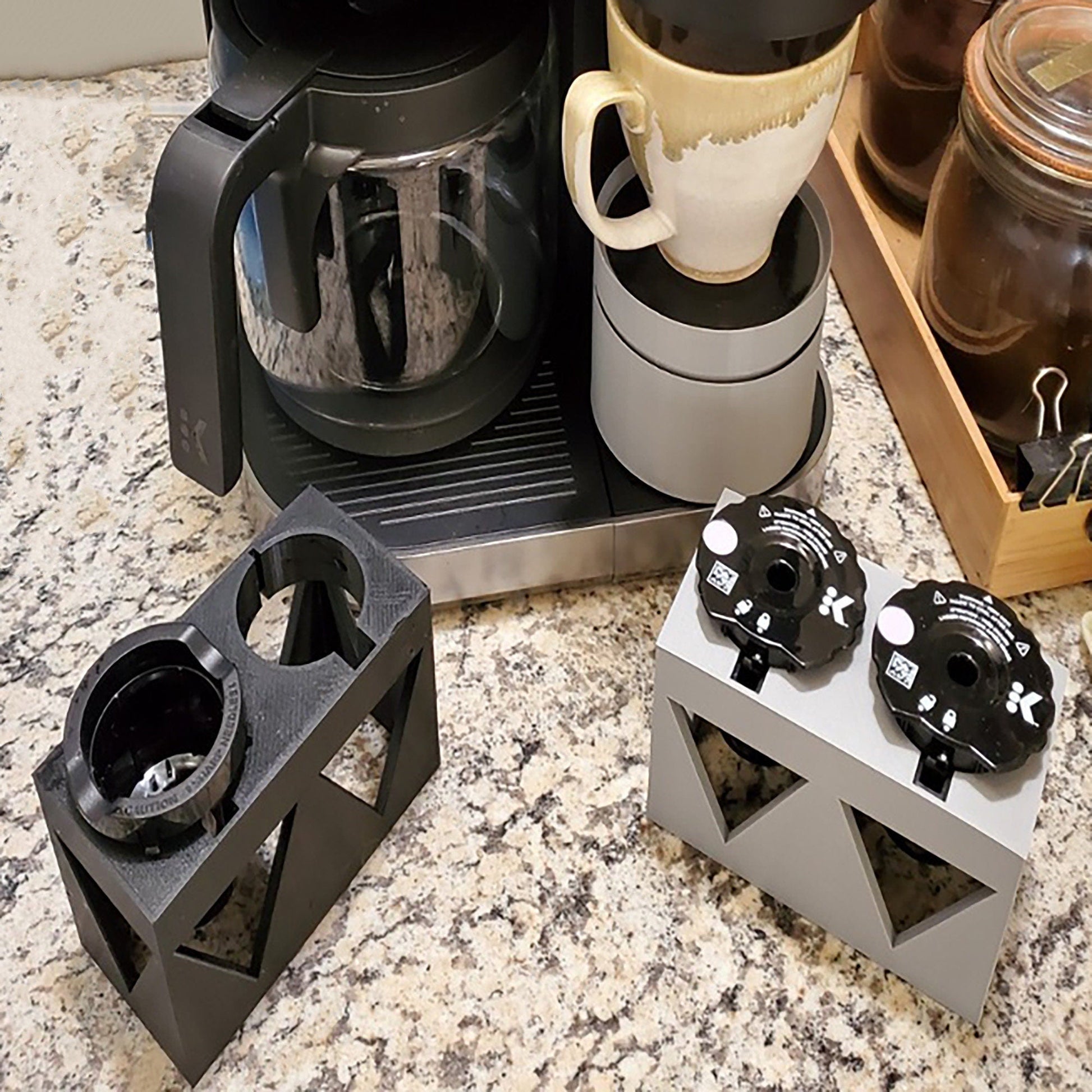 a counter top with a coffee maker and cups on it