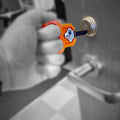 Key turner with a wide handle and finger loop holding a house key for limited grip