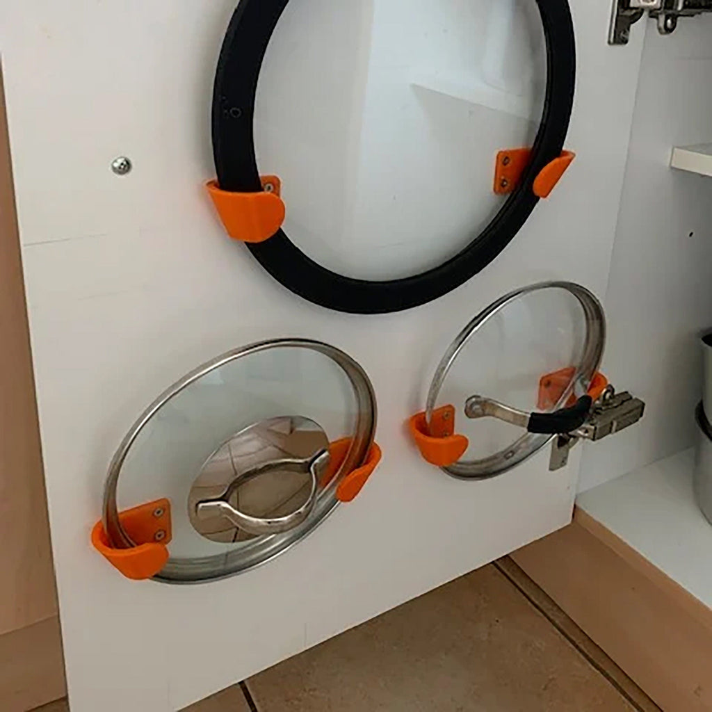 Pair of angled brackets holding a glass pot lid on a kitchen cabinet door, view 2