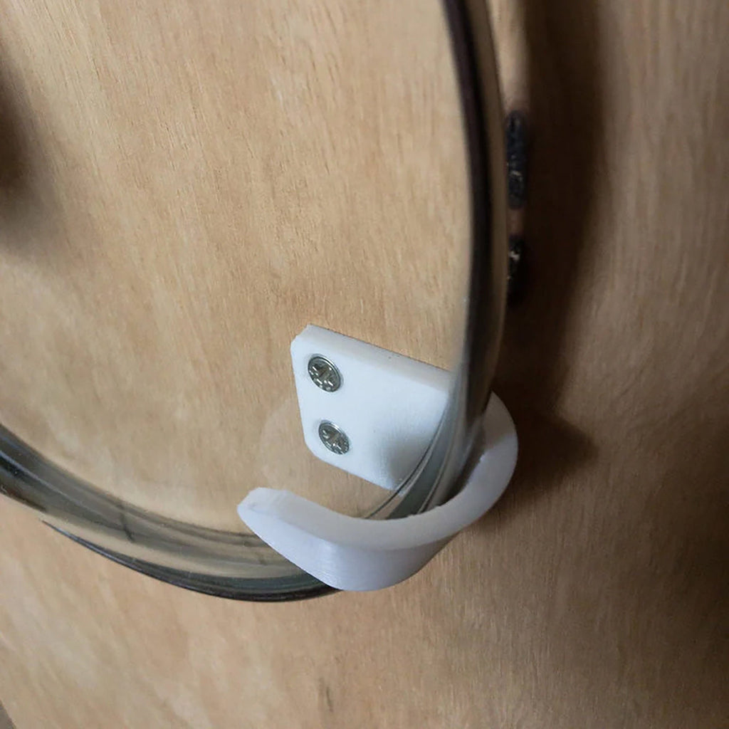 Pair of angled brackets holding a glass pot lid on a kitchen cabinet door, view 5